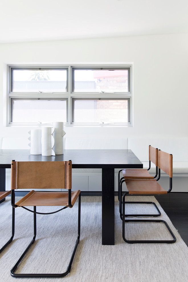 Idee per una sala da pranzo aperta verso il soggiorno eclettica di medie dimensioni con pareti bianche, pavimento in legno verniciato e pavimento nero