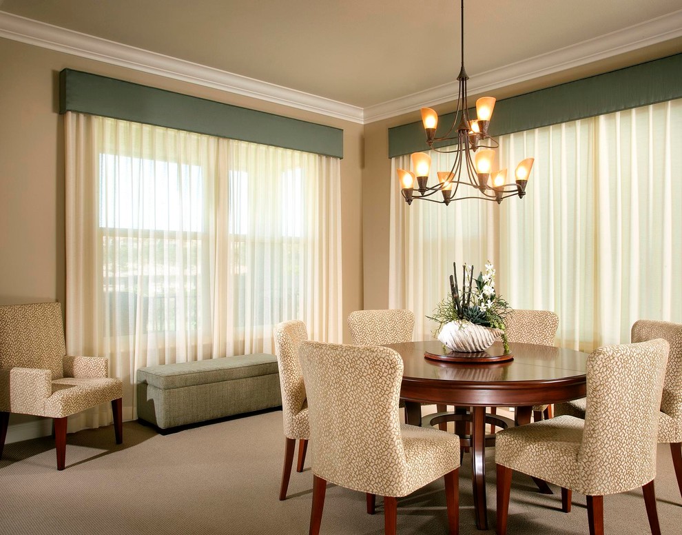 This is an example of a traditional dining room in Orange County with white walls and carpet.
