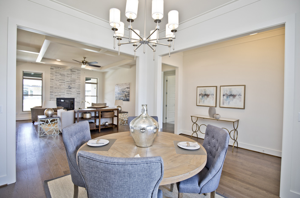 Immagine di una sala da pranzo aperta verso il soggiorno moderna di medie dimensioni con pareti bianche, parquet chiaro, nessun camino e pavimento marrone
