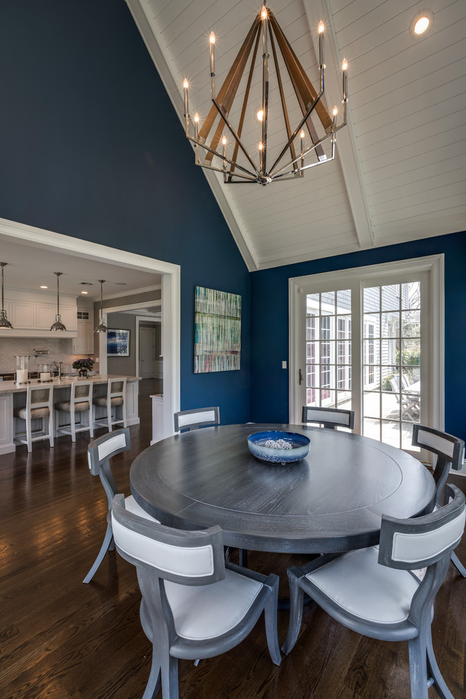 Idée de décoration pour une salle à manger ouverte sur le salon marine de taille moyenne avec un mur bleu, parquet foncé, aucune cheminée et un sol marron.