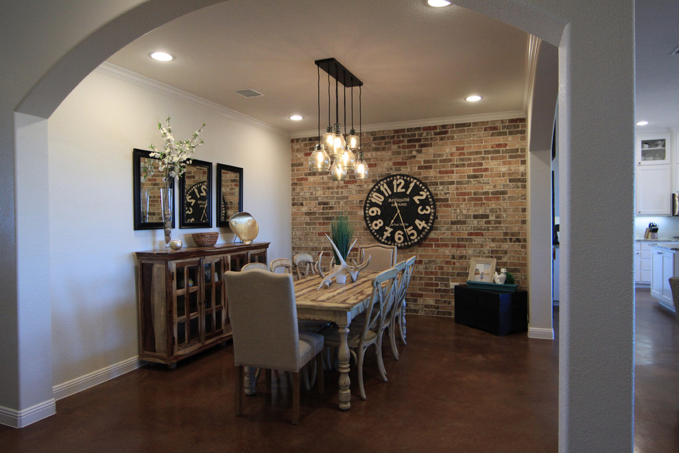 Idées déco pour une salle à manger ouverte sur la cuisine classique de taille moyenne avec un mur beige, sol en béton ciré, une cheminée d'angle et un manteau de cheminée en brique.
