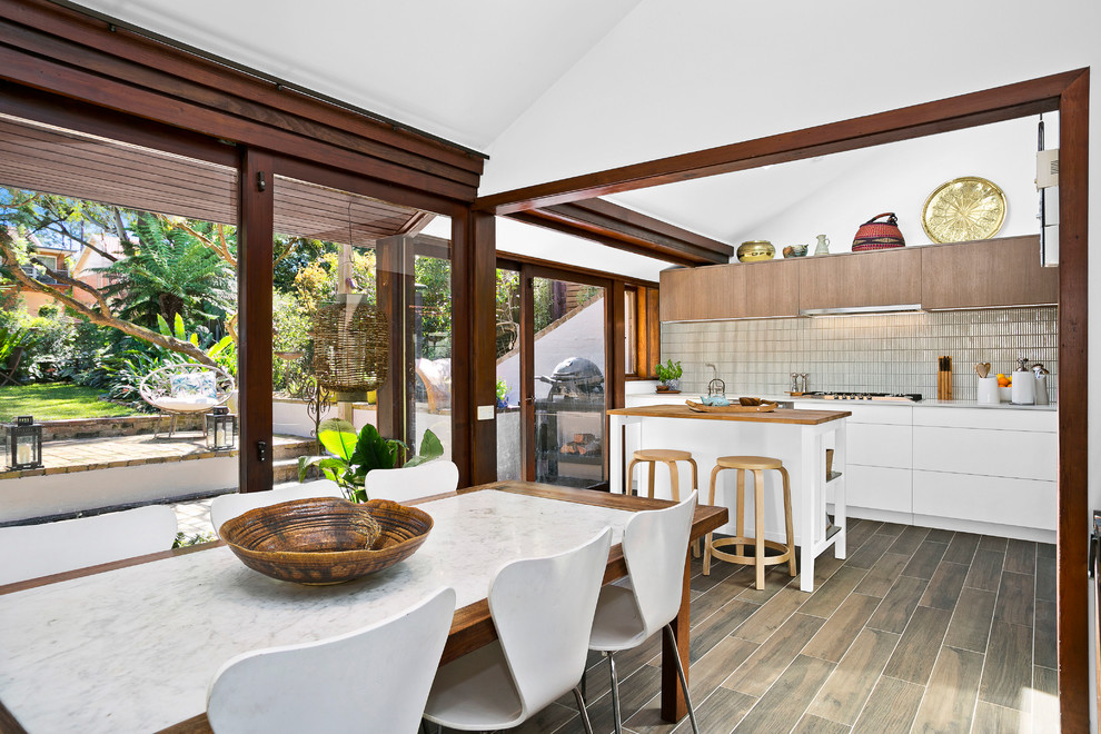 Photo of a medium sized midcentury kitchen/dining room in Sydney with white walls, dark hardwood flooring, a standard fireplace and a brick fireplace surround.
