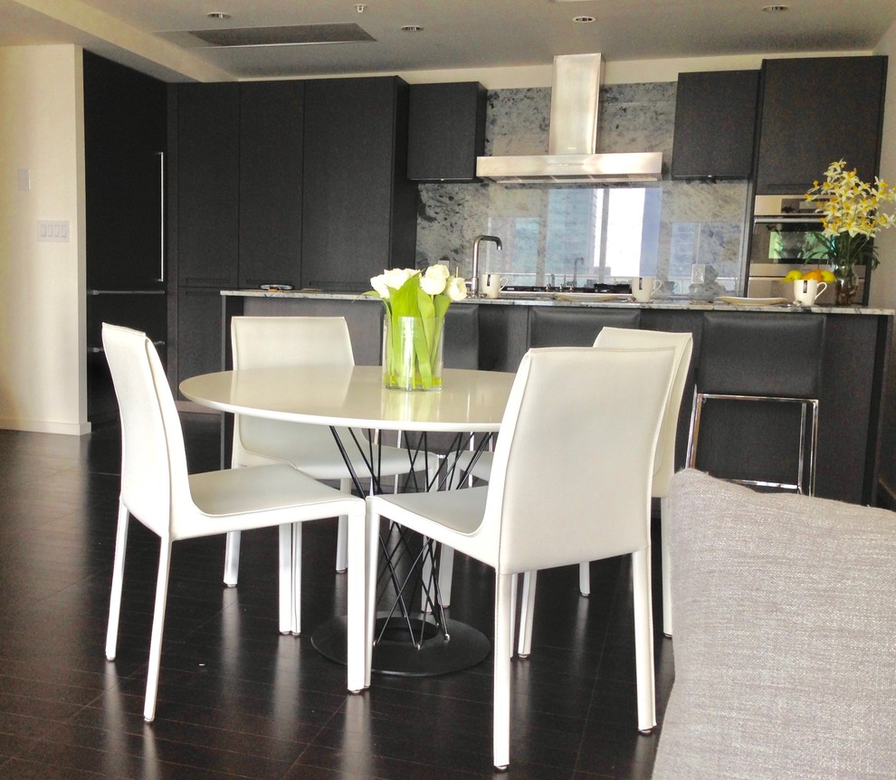 Foto di una piccola sala da pranzo aperta verso la cucina minimal con pareti bianche, parquet scuro e pavimento marrone