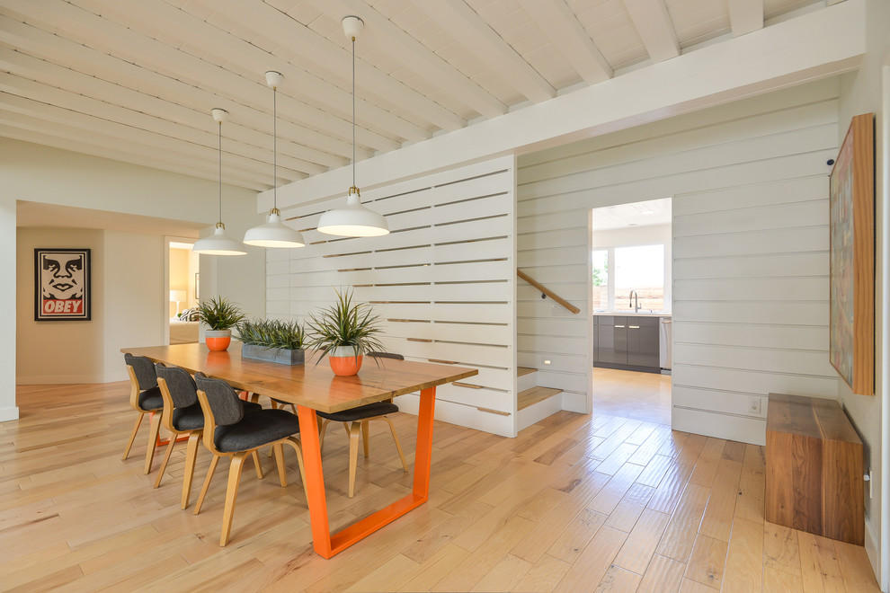 Immagine di una sala da pranzo minimalista con pareti bianche, pavimento in legno massello medio e pavimento marrone
