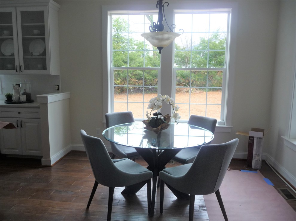 Cette photo montre une petite salle à manger ouverte sur la cuisine tendance avec un mur blanc, un sol en bois brun et un sol marron.