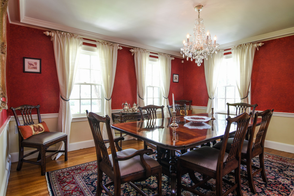 Classic enclosed dining room in Boston with red walls, medium hardwood flooring, brown floors and wainscoting.