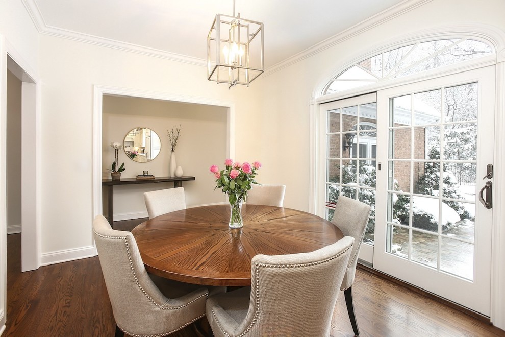 This is an example of a medium sized traditional enclosed dining room in New York with white walls, medium hardwood flooring, no fireplace and brown floors.