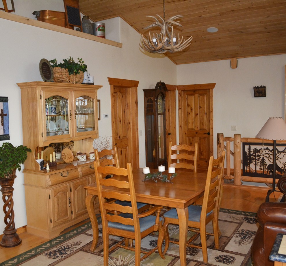 Idée de décoration pour une salle à manger ouverte sur le salon chalet de taille moyenne avec un mur blanc, un sol en linoléum, une cheminée standard et un manteau de cheminée en béton.