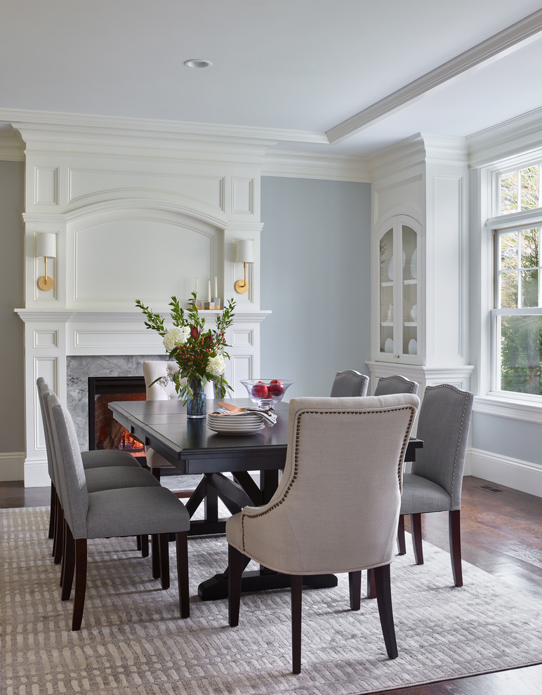 Inspiration for a large classic enclosed dining room in Boston with blue walls, dark hardwood flooring, a standard fireplace, a stone fireplace surround and brown floors.