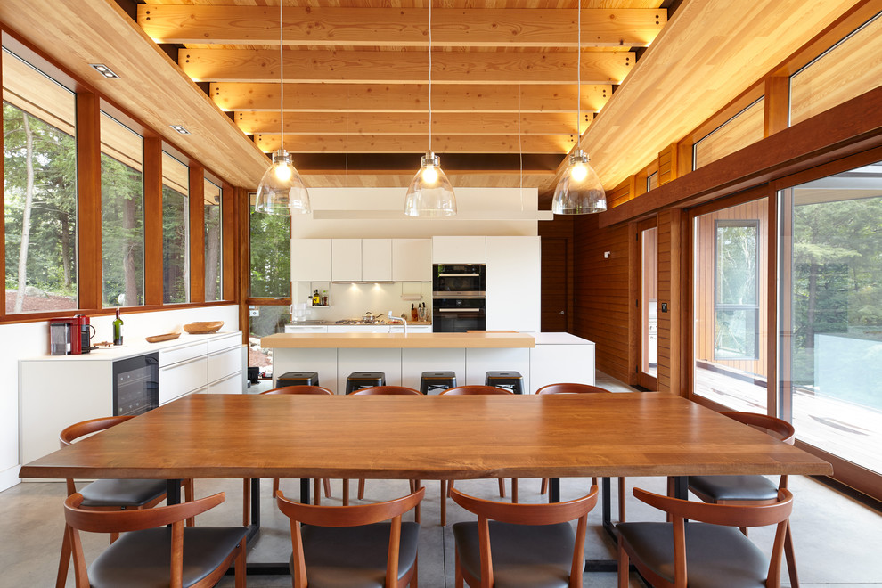 Immagine di una sala da pranzo aperta verso la cucina design con pareti bianche e pavimento grigio