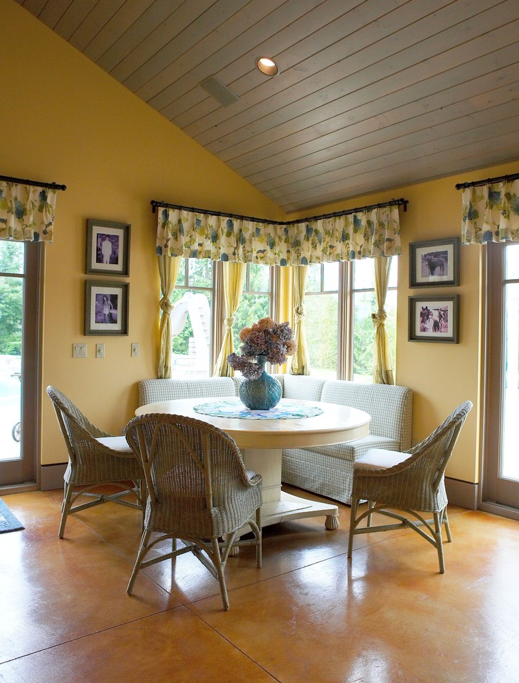 Immagine di una sala da pranzo eclettica con pareti gialle