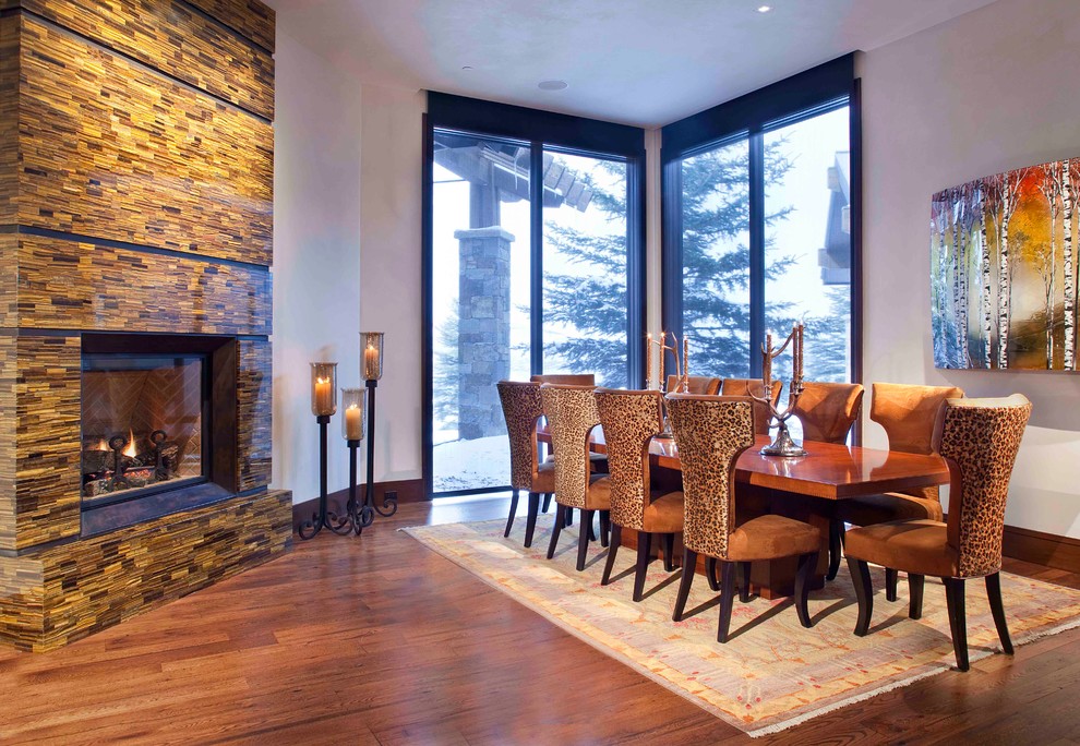Trendy dark wood floor dining room photo in Denver with gray walls and a standard fireplace