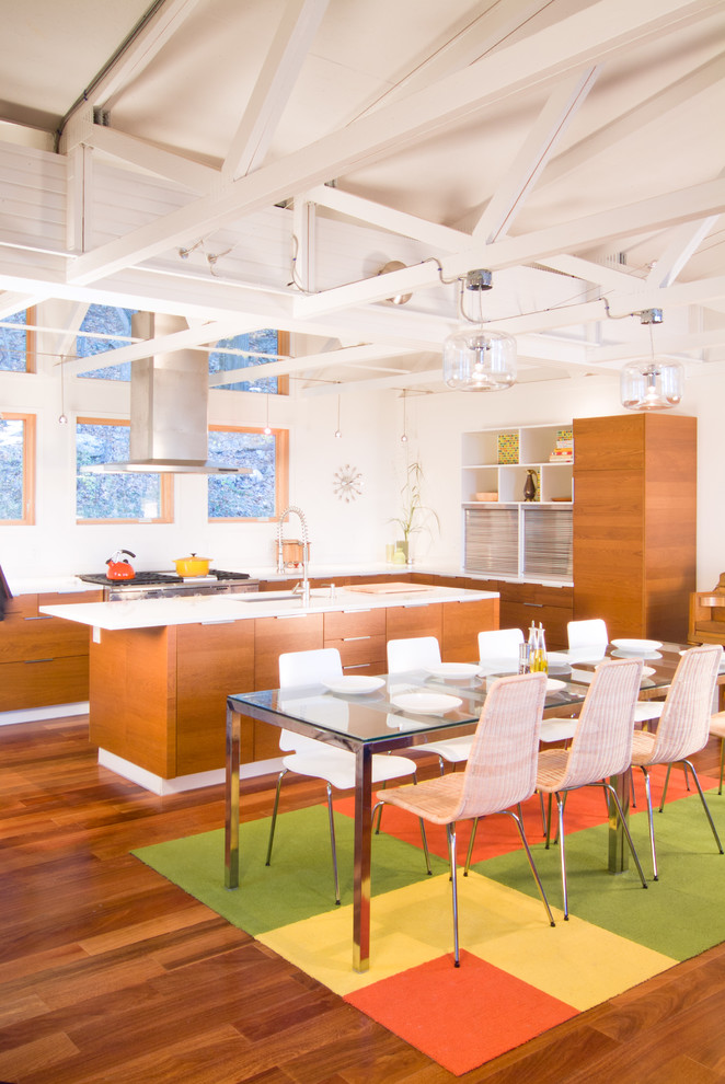 Idee per una sala da pranzo aperta verso la cucina design con pareti bianche e pavimento in legno massello medio