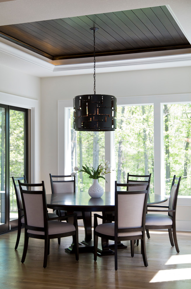 Inspiration pour une grande salle à manger ouverte sur le salon minimaliste avec un mur blanc, un sol en bois brun et un sol marron.