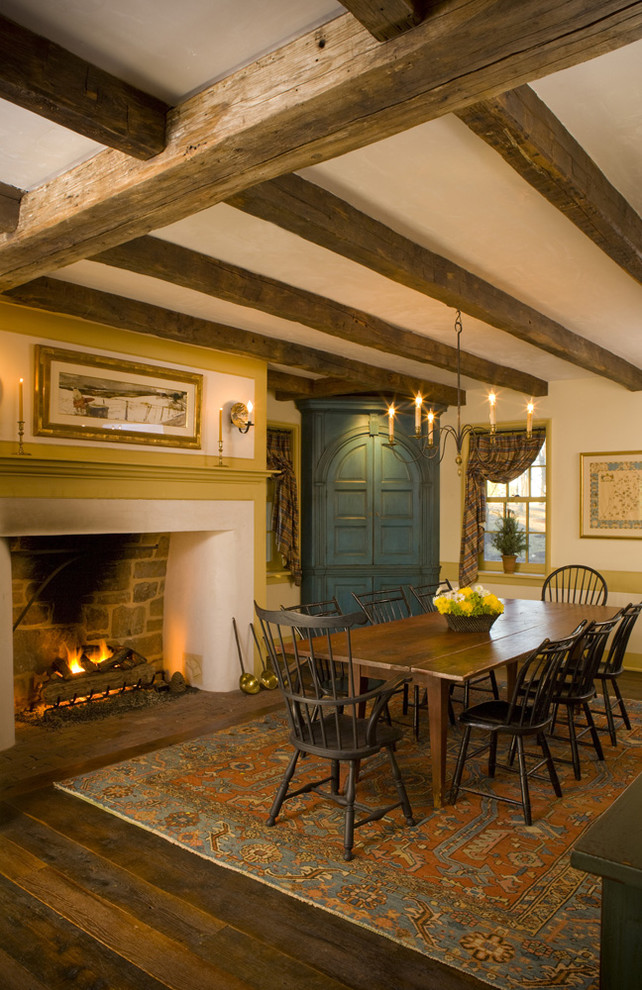 Cette image montre une salle à manger chalet fermée et de taille moyenne avec un mur beige, parquet foncé, une cheminée standard et un manteau de cheminée en plâtre.