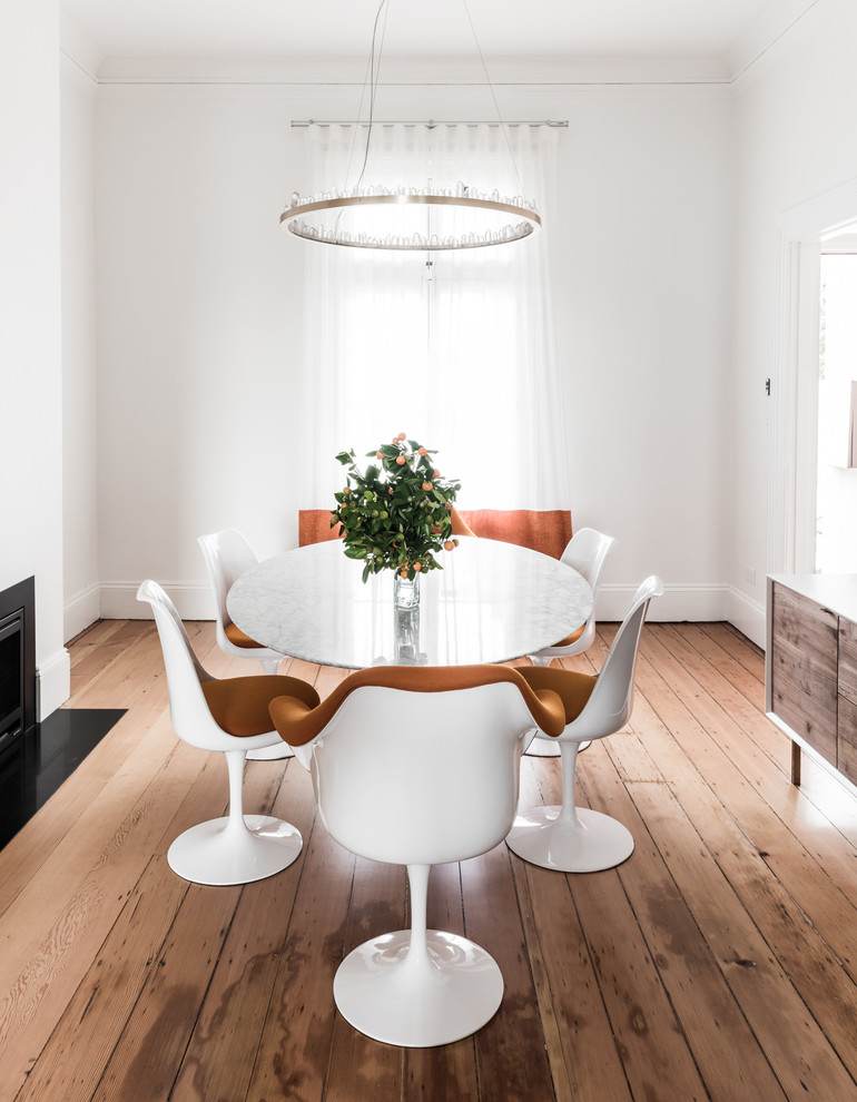 Mittelgroße Moderne Wohnküche mit weißer Wandfarbe, hellem Holzboden, Kamin, Kaminumrandung aus Metall und braunem Boden in Sydney