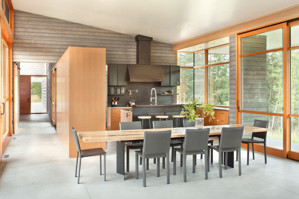 Idee per una sala da pranzo aperta verso la cucina minimal con pavimento in cemento