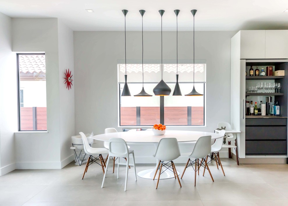 Esempio di una sala da pranzo aperta verso la cucina minimal di medie dimensioni con pareti bianche, pavimento beige, pavimento in cemento e nessun camino