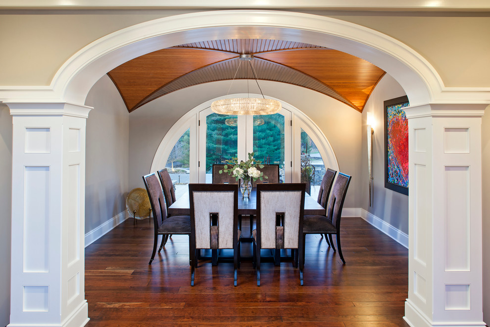 Immagine di una sala da pranzo tradizionale con pavimento in legno massello medio e pareti grigie
