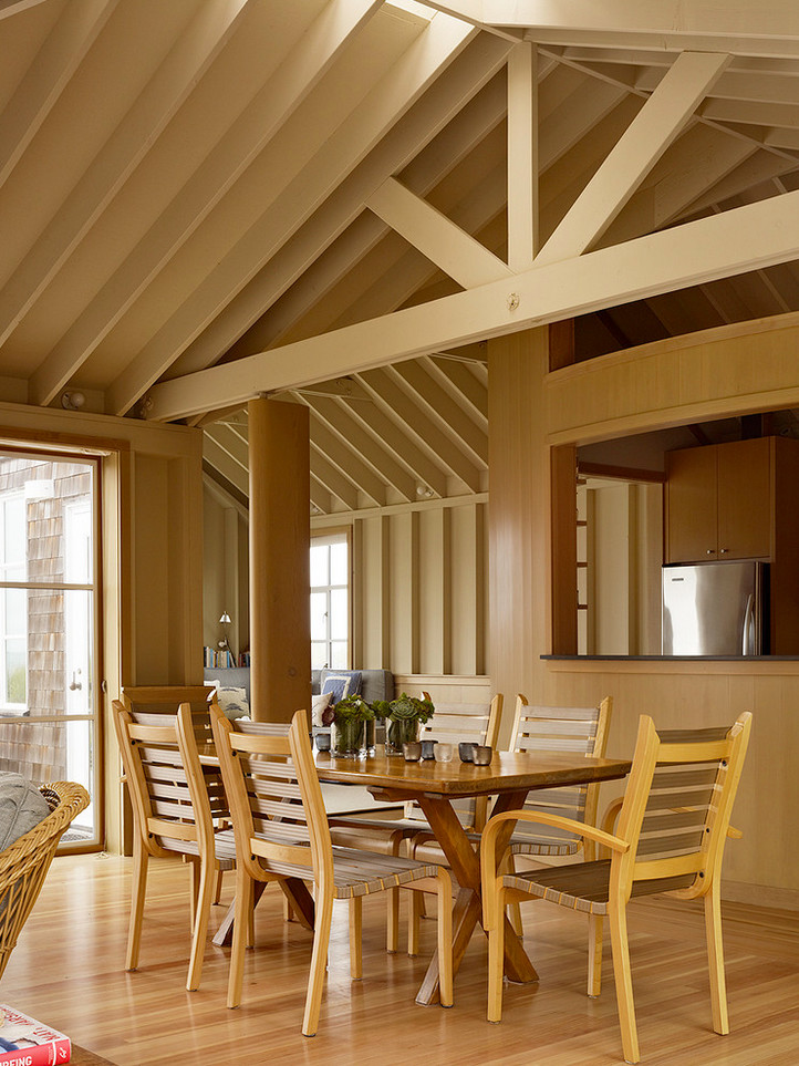 Immagine di una piccola sala da pranzo aperta verso il soggiorno stile marinaro con pareti beige, parquet chiaro e nessun camino