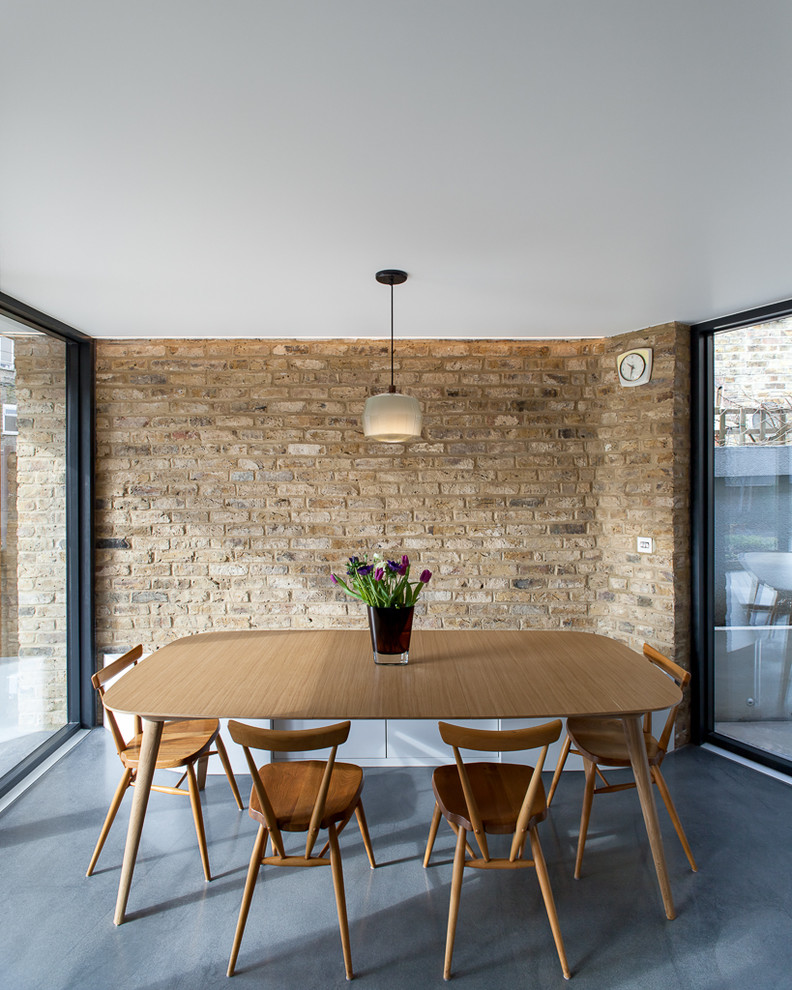 На фото: столовая среднего размера в современном стиле с бетонным полом и серым полом без камина с