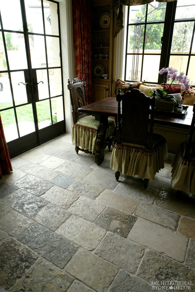 Ispirazione per una grande sala da pranzo aperta verso il soggiorno mediterranea con pavimento in pietra calcarea