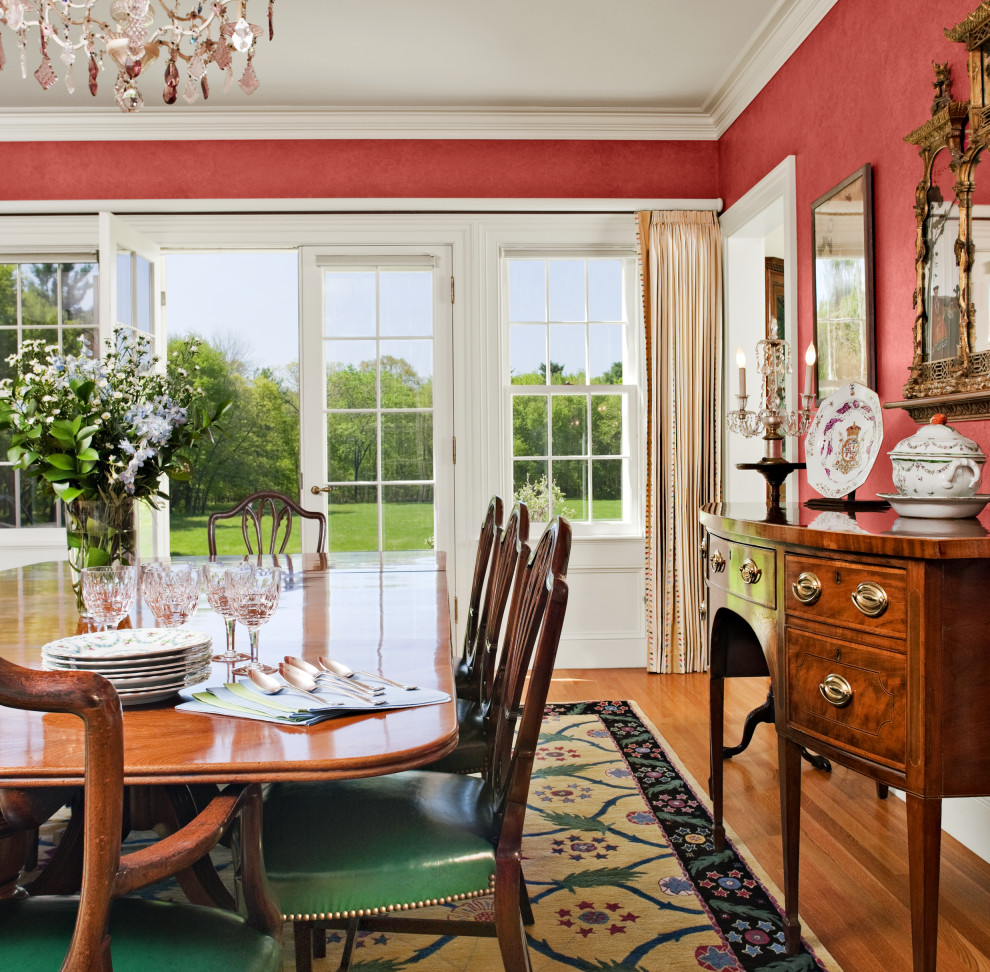 Foto di una sala da pranzo country chiusa con pareti rosse e pavimento in legno massello medio