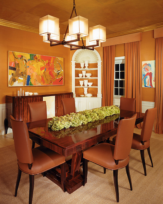 Foto di una sala da pranzo aperta verso la cucina classica di medie dimensioni con pareti arancioni, parquet scuro e pavimento marrone