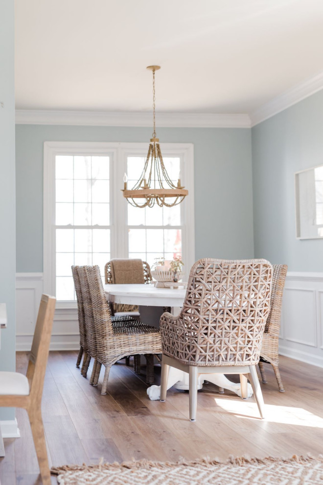 Immagine di una sala da pranzo aperta verso il soggiorno stile marino di medie dimensioni con pareti blu, pavimento in laminato e pavimento marrone