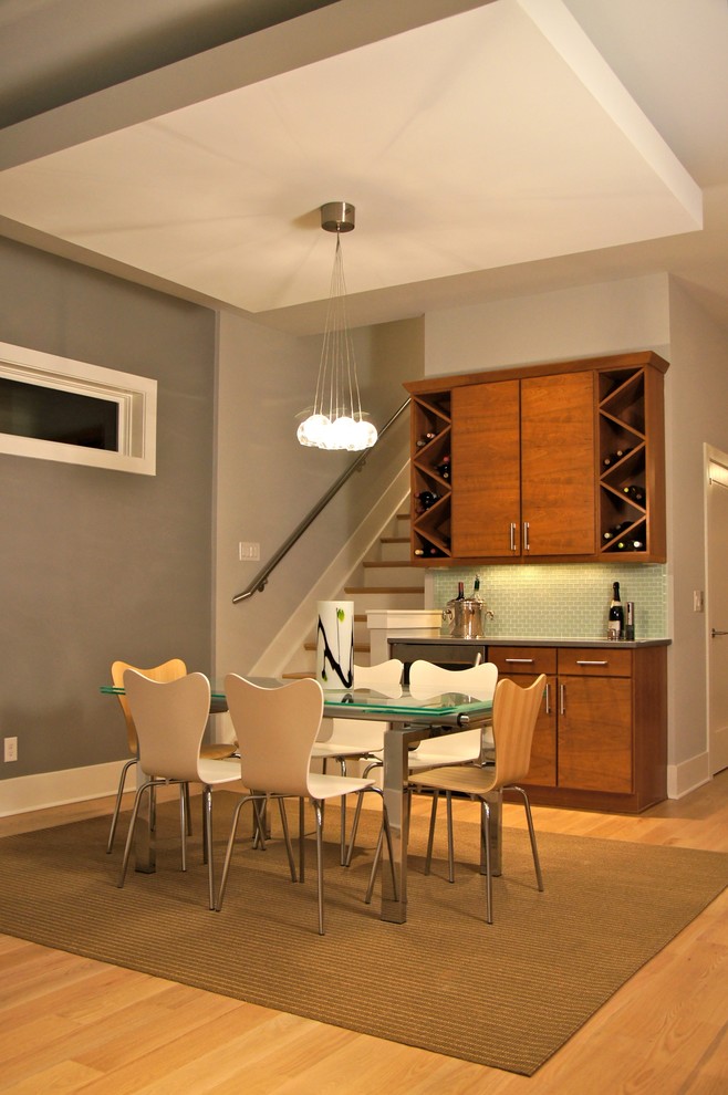 Example of a minimalist medium tone wood floor dining room design in Cincinnati with gray walls