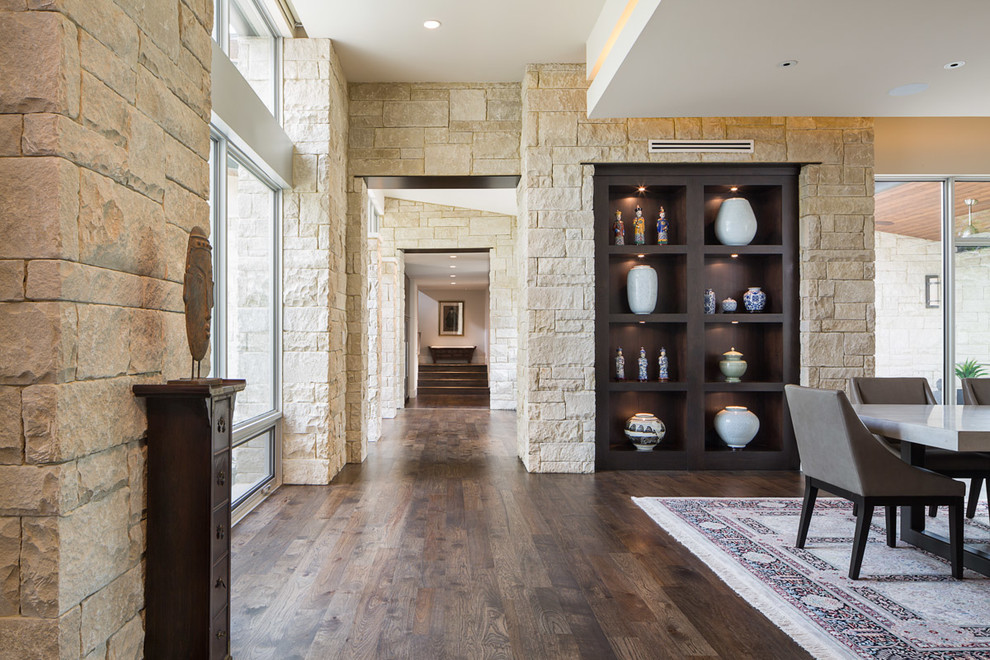 Offenes, Großes Modernes Esszimmer ohne Kamin mit beiger Wandfarbe und dunklem Holzboden in Austin