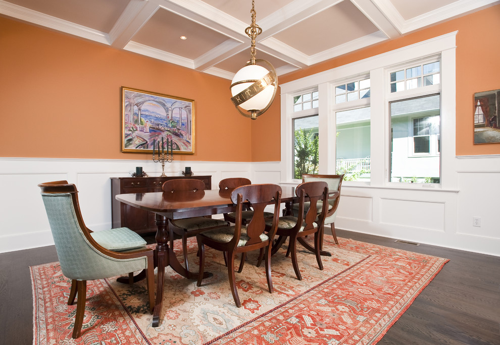 Klassisches Esszimmer mit oranger Wandfarbe und dunklem Holzboden in Seattle