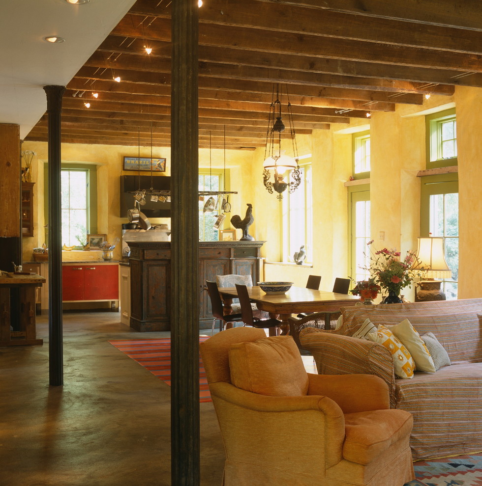 Inspiration for a mid-sized country concrete floor and brown floor great room remodel in Baltimore with yellow walls and no fireplace