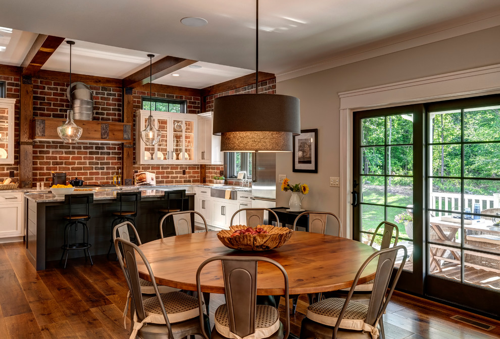 Cette photo montre une grande salle à manger ouverte sur la cuisine chic avec un mur gris et un sol en bois brun.