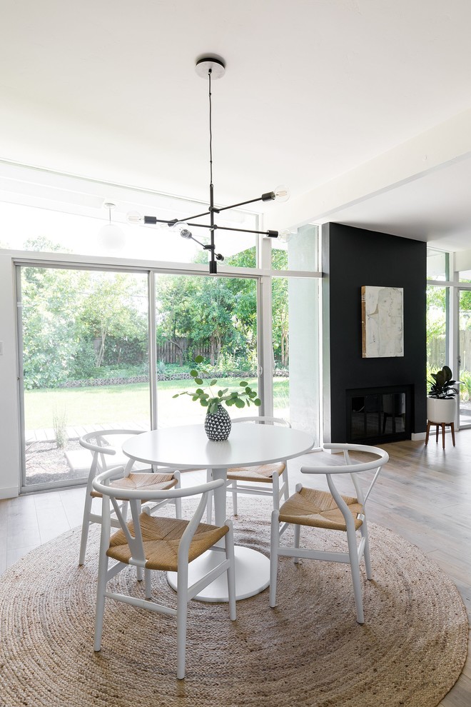 Retro dining room in Sacramento with black walls, no fireplace, beige floors and light hardwood flooring.