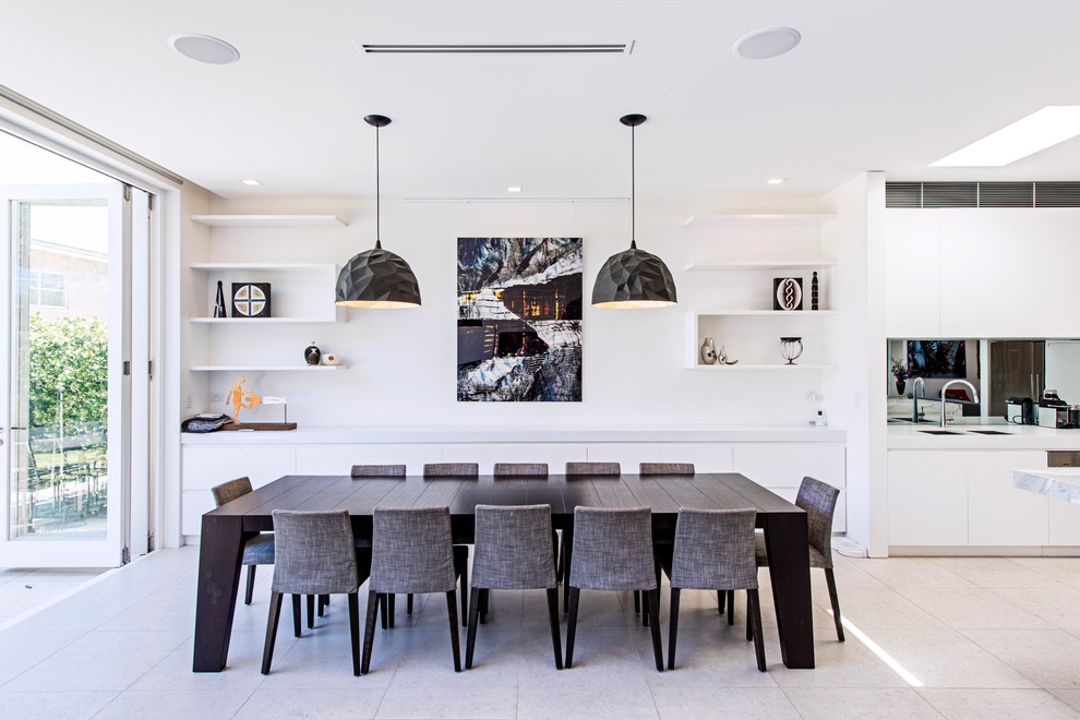 Contemporary kitchen/dining room in Sydney with white walls, beige floors and feature lighting.