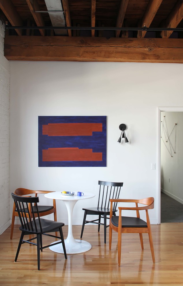 Foto di una sala da pranzo moderna con pareti bianche, pavimento in legno massello medio e pavimento beige