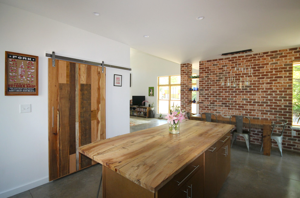 Ispirazione per una piccola sala da pranzo aperta verso la cucina stile rurale con pareti multicolore e pavimento in cemento