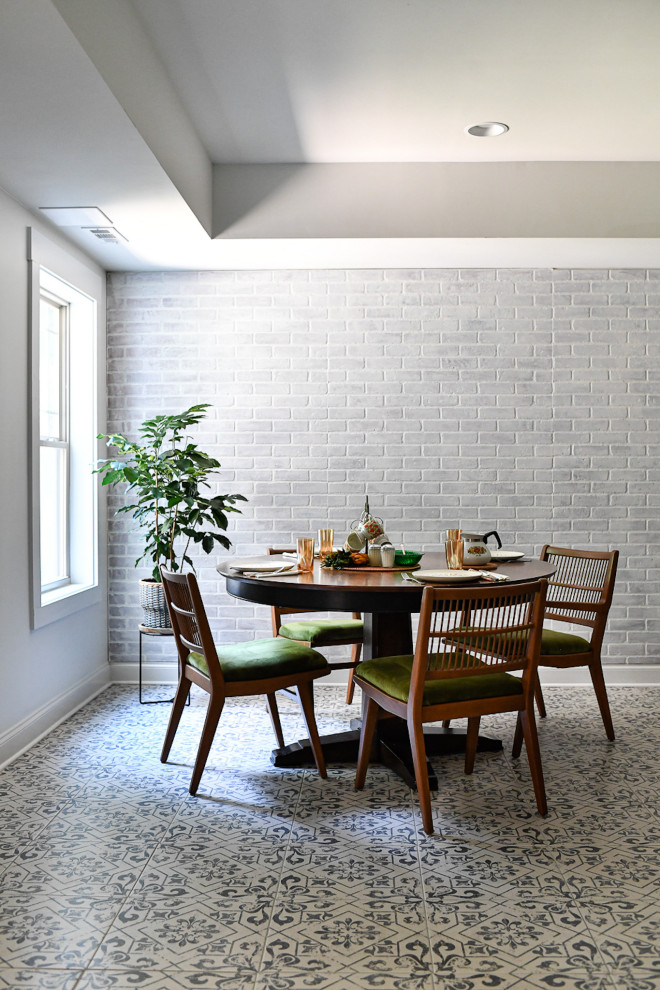 Immagine di una sala da pranzo aperta verso la cucina mediterranea di medie dimensioni con pareti bianche, pavimento in gres porcellanato, pavimento blu e pareti in mattoni