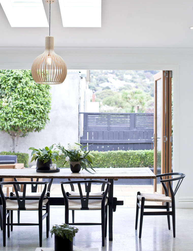 Ispirazione per una sala da pranzo stile marinaro con pareti bianche e pavimento in cemento