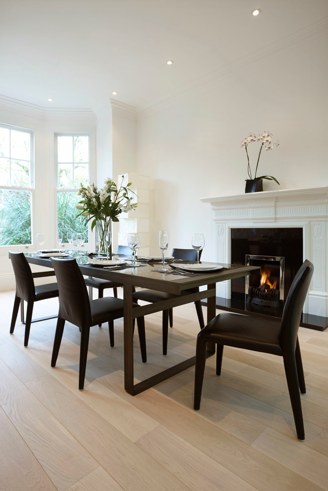 Idées déco pour une salle à manger victorienne avec un mur blanc, parquet clair et une cheminée standard.