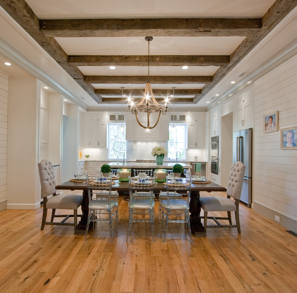 Immagine di una sala da pranzo aperta verso la cucina classica con pareti bianche e pavimento in legno massello medio