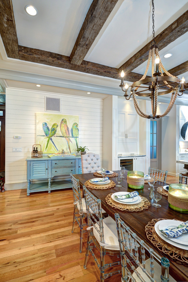 Design ideas for a coastal dining room in Charleston with feature lighting.