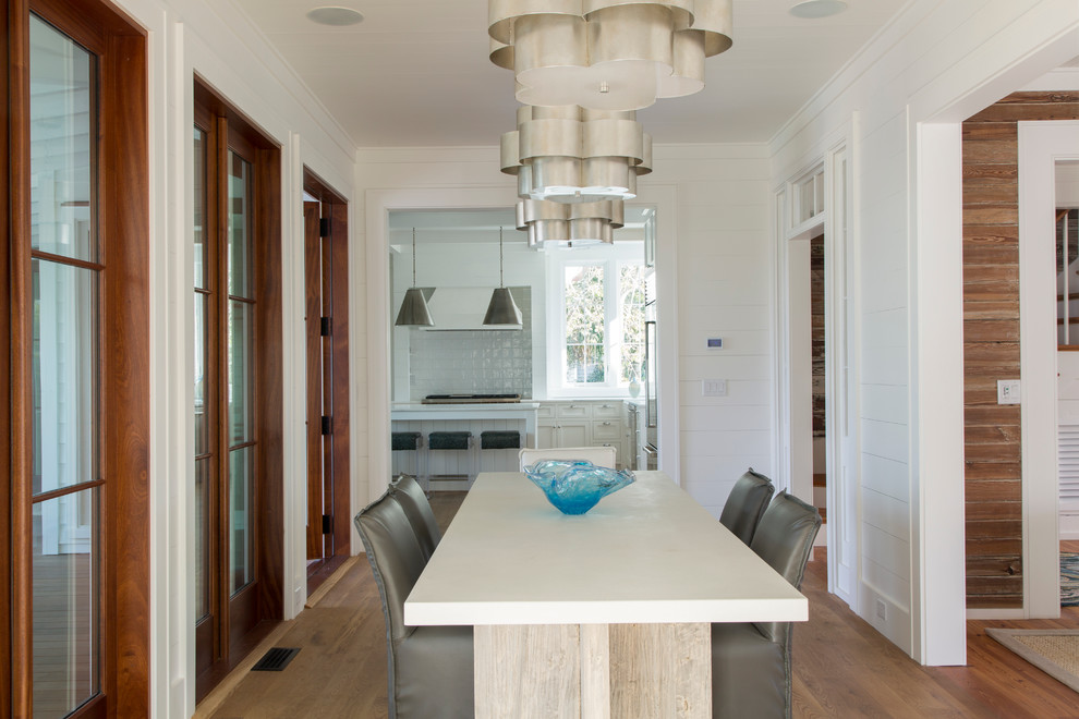 Design ideas for a nautical dining room in Charleston with white walls and medium hardwood flooring.