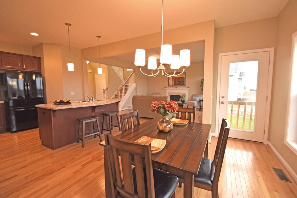 Exemple d'une grande salle à manger ouverte sur la cuisine chic avec un mur beige et parquet clair.