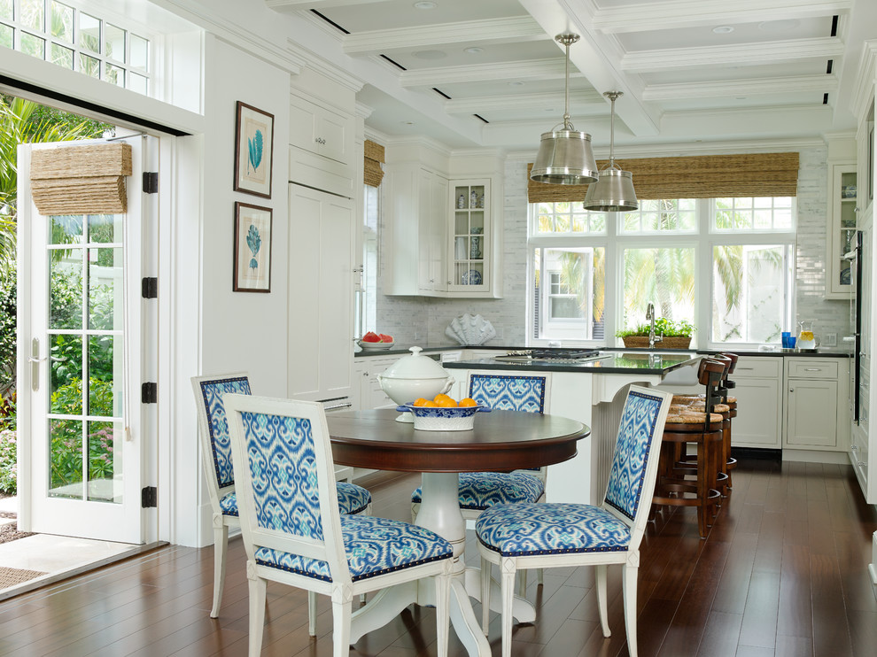 Foto di una sala da pranzo aperta verso la cucina stile marinaro con pareti bianche, parquet scuro e pavimento marrone