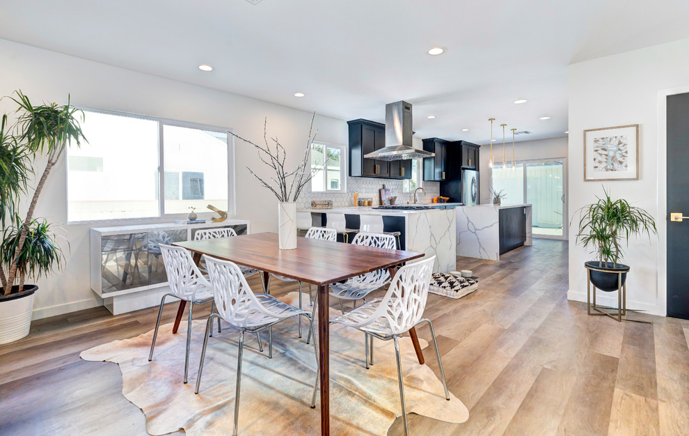 Idee per una sala da pranzo aperta verso la cucina tradizionale con pareti bianche, pavimento in legno massello medio e pavimento marrone