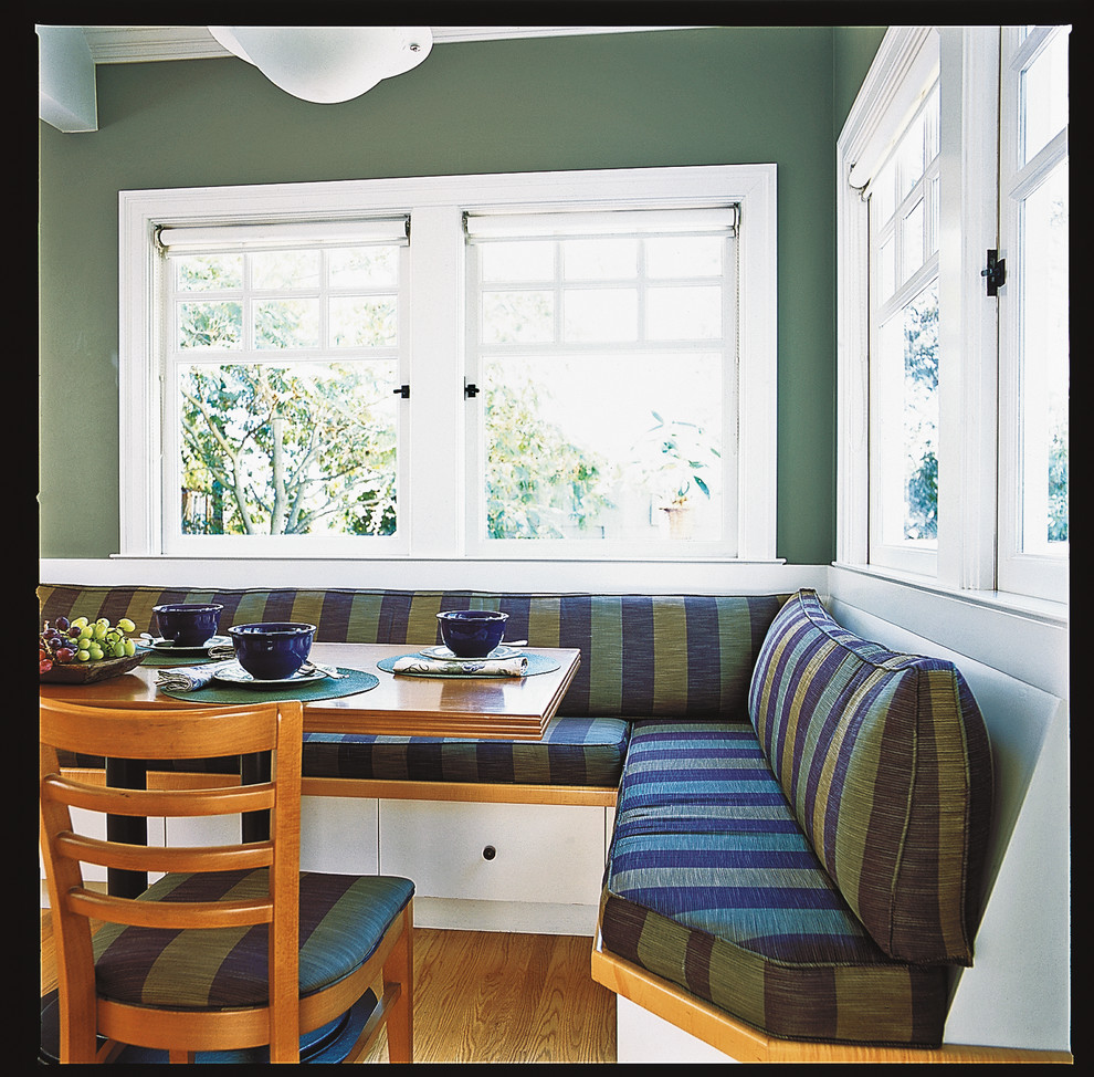 Ejemplo de comedor de cocina de estilo americano de tamaño medio con paredes verdes y suelo de madera clara
