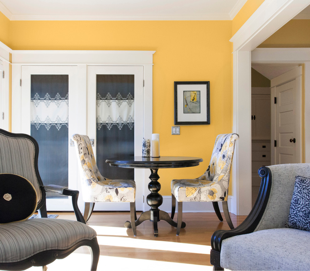 Photo of a small contemporary open plan dining room in Portland with yellow walls and light hardwood flooring.