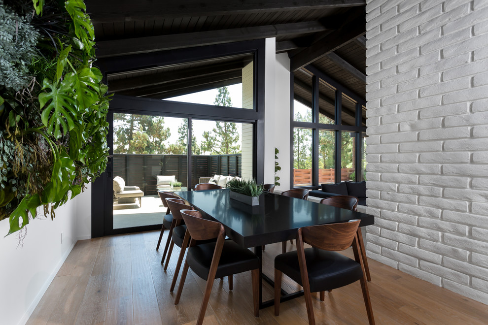 Diseño de comedor retro grande abierto sin chimenea con paredes blancas, suelo de madera clara y suelo beige